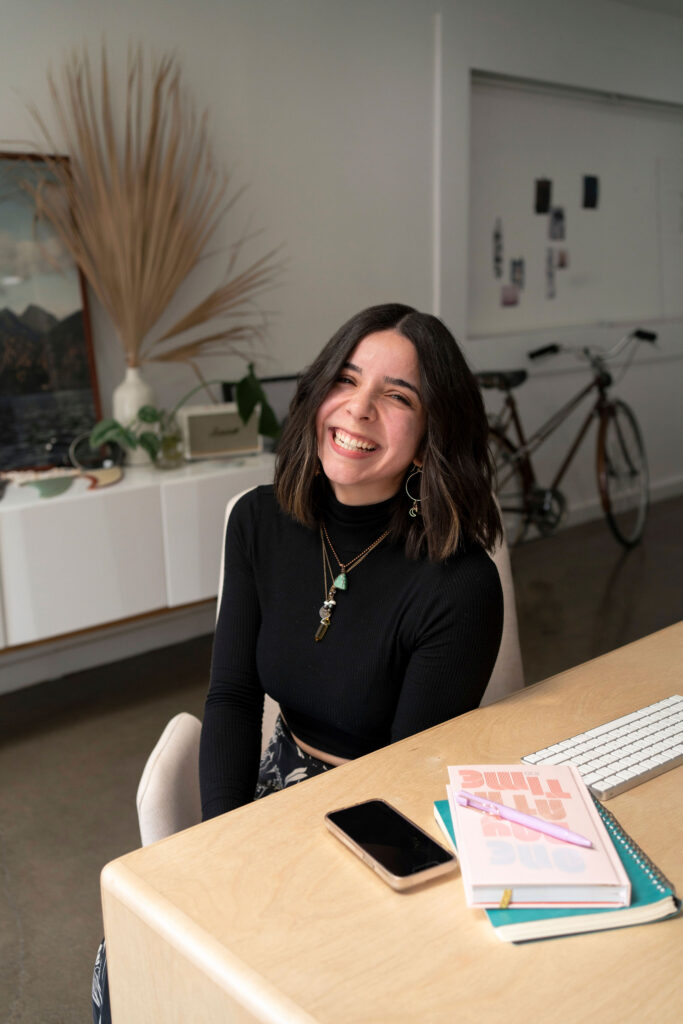 Nicole sturgeon LLC, a Pinterest and blogging manager smiling sitting at a desj 